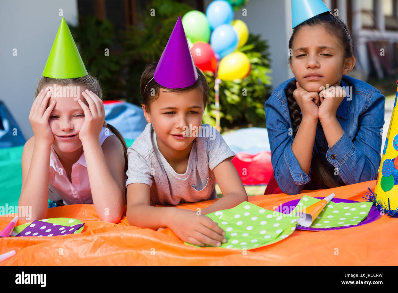 Bambini annoiati seduti al tavolo durante bithday in cantiere Foto Stock