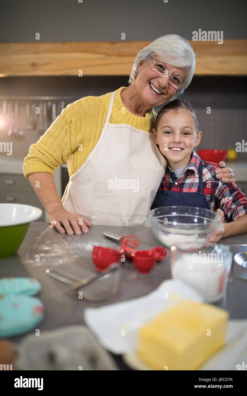 Nonna sorridente e nipote abbracciando in cucina Foto Stock