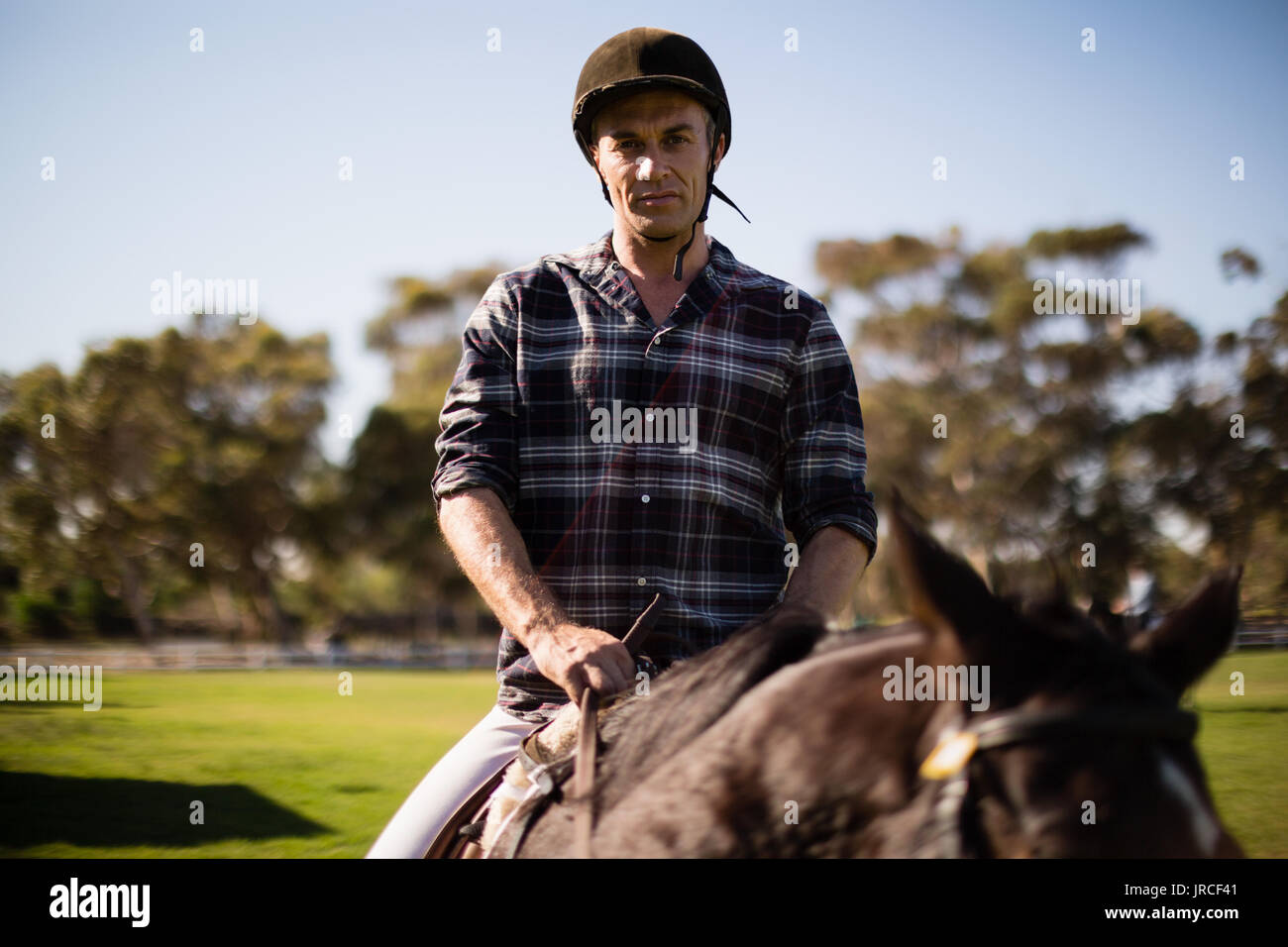 Uomo a cavallo nel ranch in una giornata di sole Foto Stock