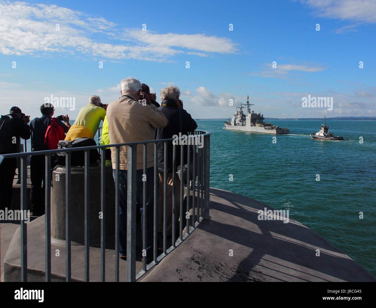 Fotografi raccogliere sulla sommità della torre rotonda all'ingresso del porto di Portsmouth a fotografare USS Mare delle Filippine (Cg-58) lasciando la porta. Foto Stock