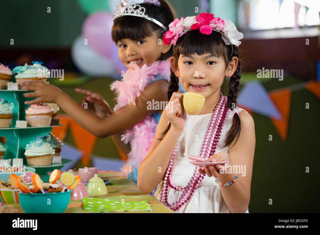 Ritratto di cute ragazze avente il tè durante la festa di compleanno a casa Foto Stock