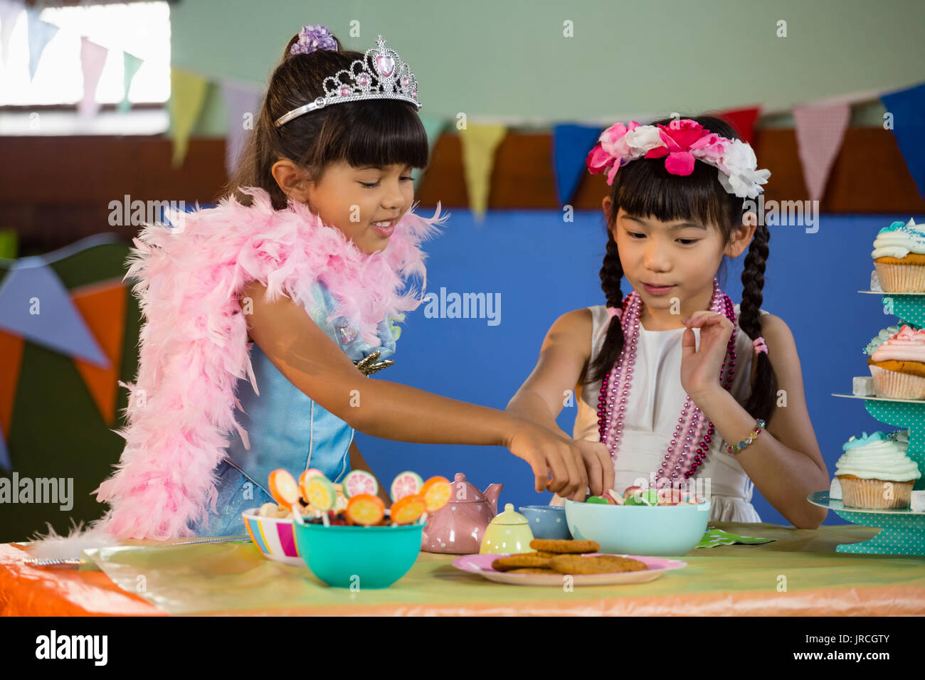 Cute ragazze avente dolciumi durante la festa di compleanno a casa Foto Stock