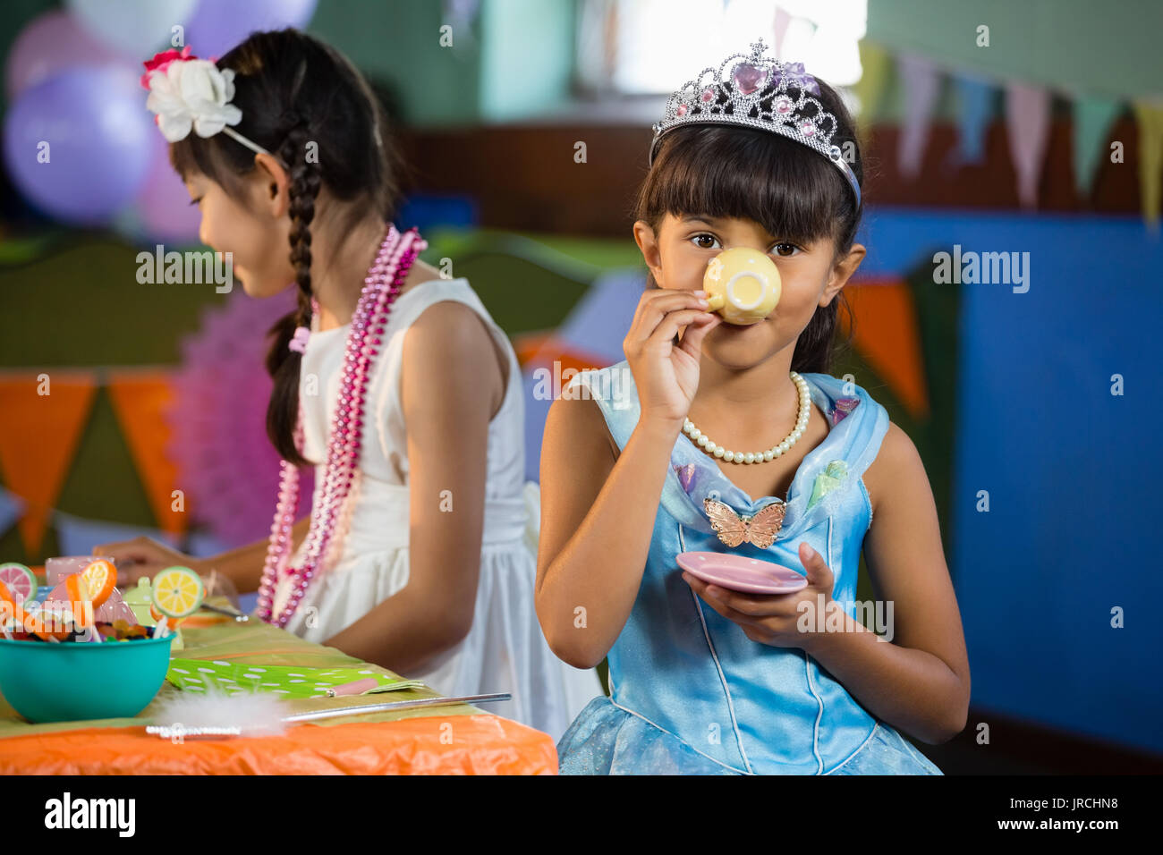 Cute ragazze avente il tè al tavolo durante la festa di compleanno a casa Foto Stock