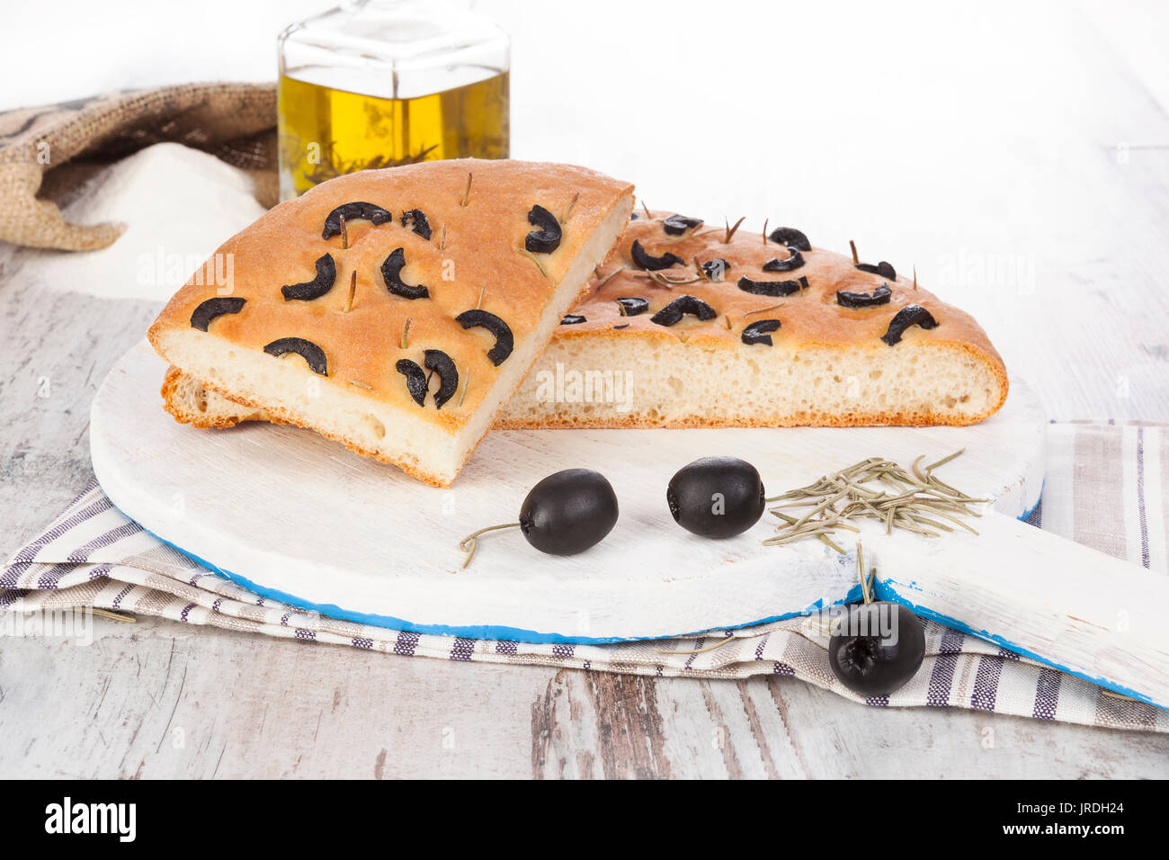Pane con olive e olio sul tagliere con erbe aromatiche, foccacia. Deliziosa focaccia pane rustico. Foto Stock
