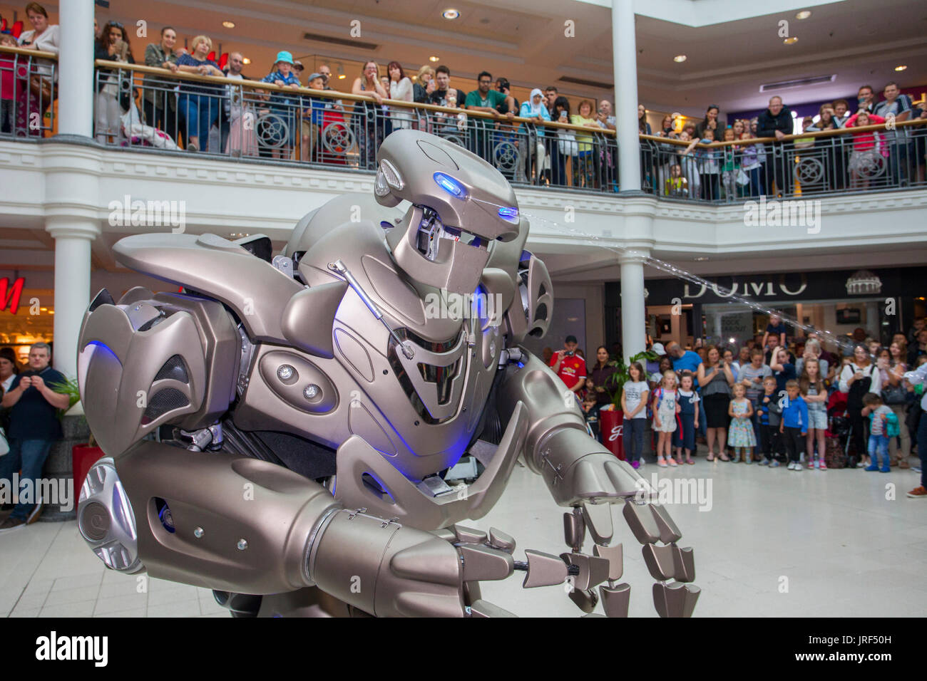 Preston, Lancashire, Regno Unito. Titan il robot, indossando un esoscheletro suit, incanta la folla di St George's Center. Titan è il nome di fase di un parzialmente costume meccanizzato creato da Cyberstein Robots Ltd. Il robot costume è circa 2,4 metri (7,9 piedi) di altezza e 60 kg e aumenta a 350 kg compreso il carrello scorre su e apparecchiatura di bordo. La faccia assomiglia ad un teschio e alcune hanno anche paragonato a un trasformatore. È stato progettato da Nik Fielding, che corre da Cyberstein, Newquay Cornwall, Inghilterra. Foto Stock