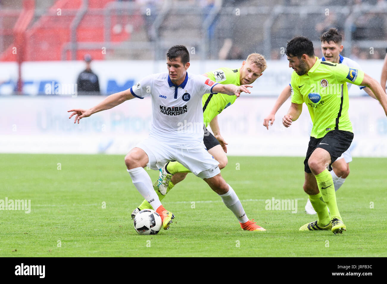 Oskar Zawada (KSC) im Zweikampf mit Patrick Funk (Wiesbaden) und Sascha Mockenhaupt (Wiesbaden), (von links). GES/ Fussball/ 3. Liga: Karlsruher SC - Wehen Wiesbaden, 05.08.2017 -- calcio/ Soccer 3° Divisione: Karlsruher SC vs Wehen Wiesbaden, Karlsruhe, 05 agosto 2017 -- | Verwendung weltweit Foto Stock