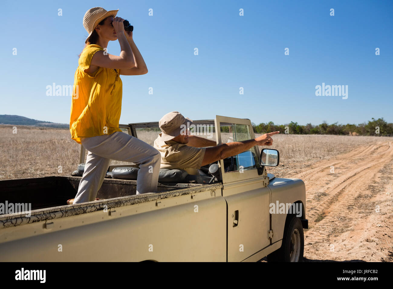 L'uomo con la donna rivolta durante la guida fuoristrada sul paesaggio contro il cielo chiaro Foto Stock