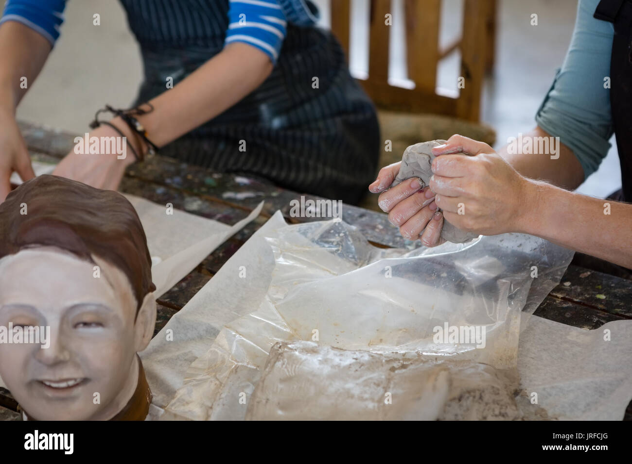 Gli studenti adulti rendendo la scultura in argilla in classe d'arte Foto Stock