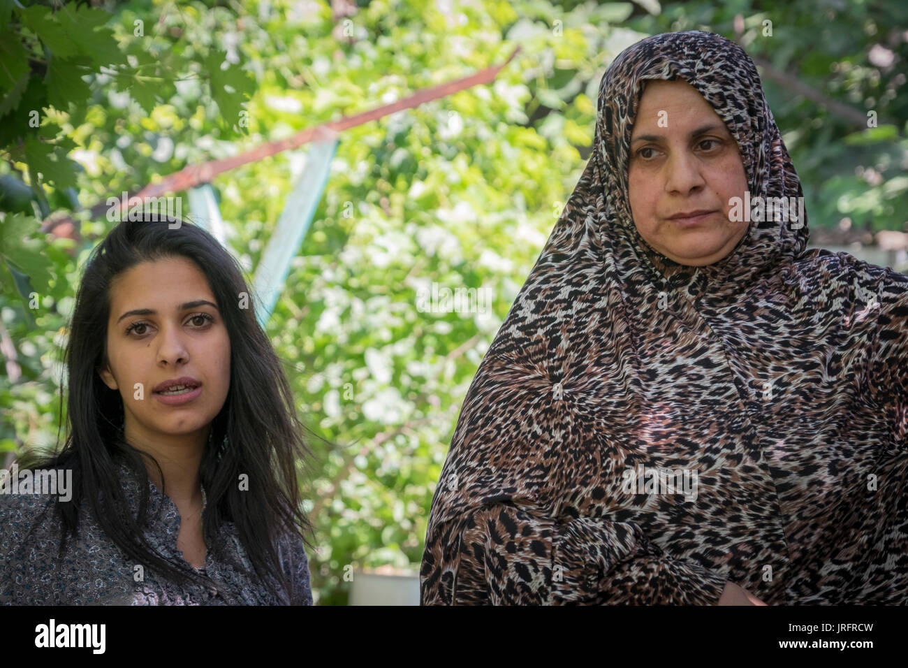 Madre palestinese e la figlia di descrivere le loro interazioni con i loro coloni israeliani vicini nel centro di Hebron nei territori occupati Foto Stock