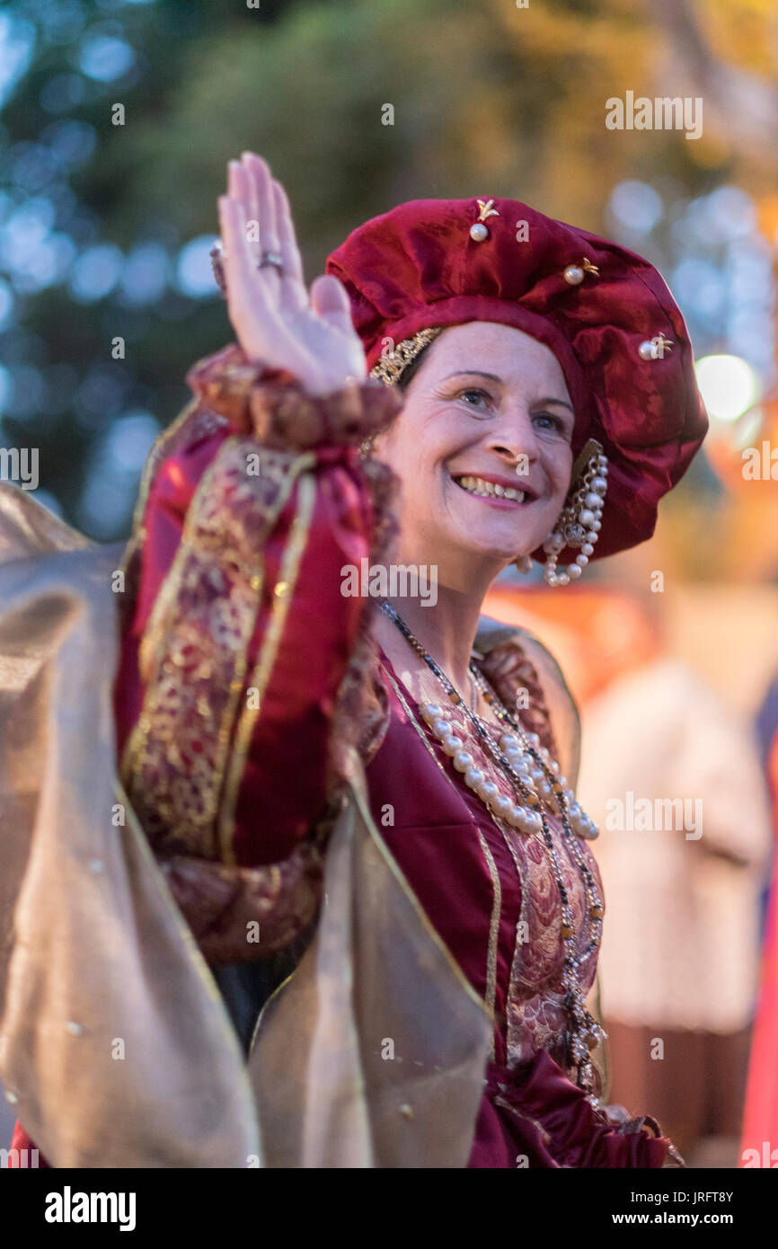 La regina del Renaissance festival in Francia meridionale onde ai suoi ammiratori mentre vestita in un elaborato costume dell'epoca tra cui gioielli & vestaglia. Foto Stock