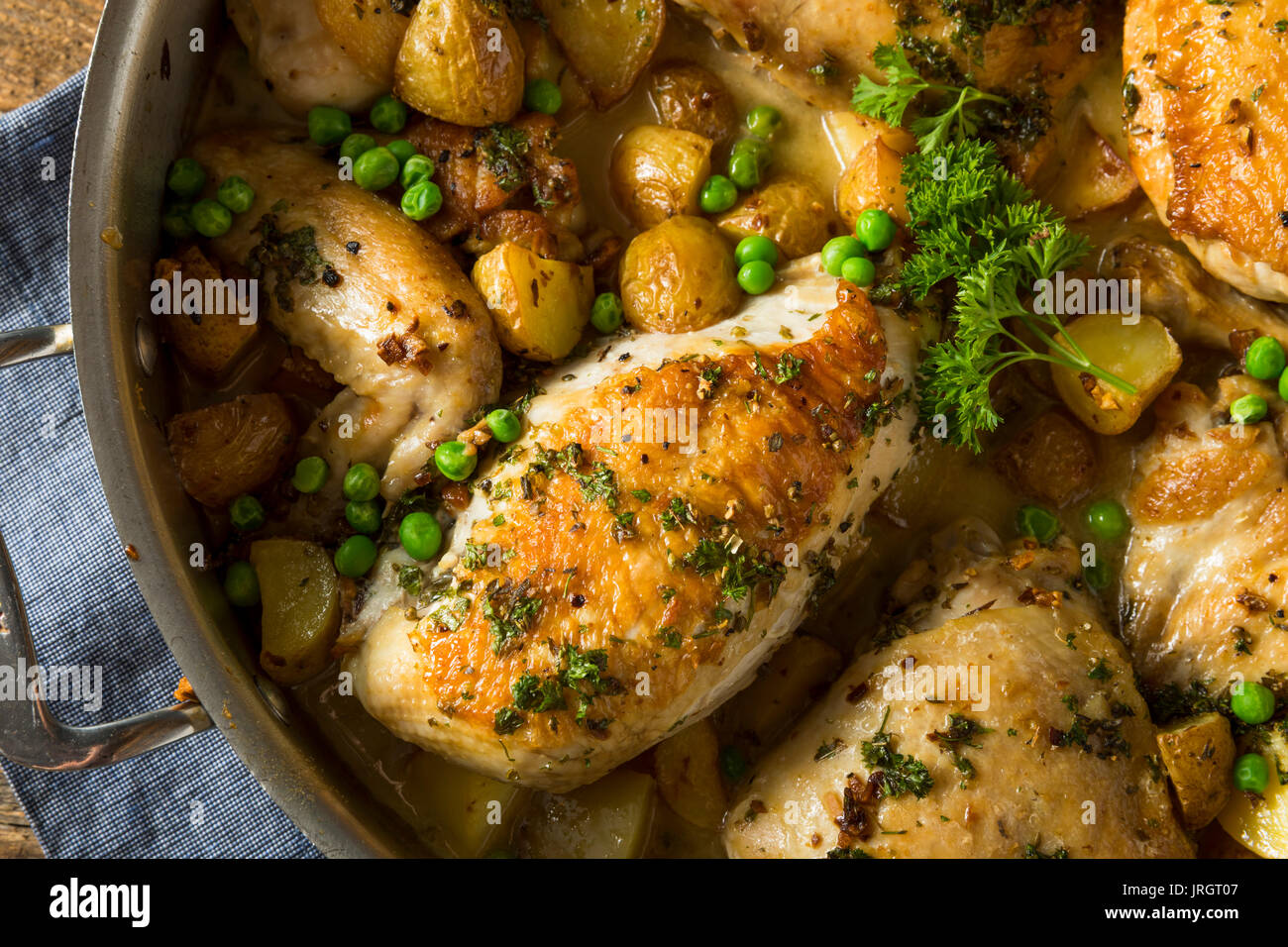 In casa il pollo al forno Vesuvio con piselli e patate Foto Stock