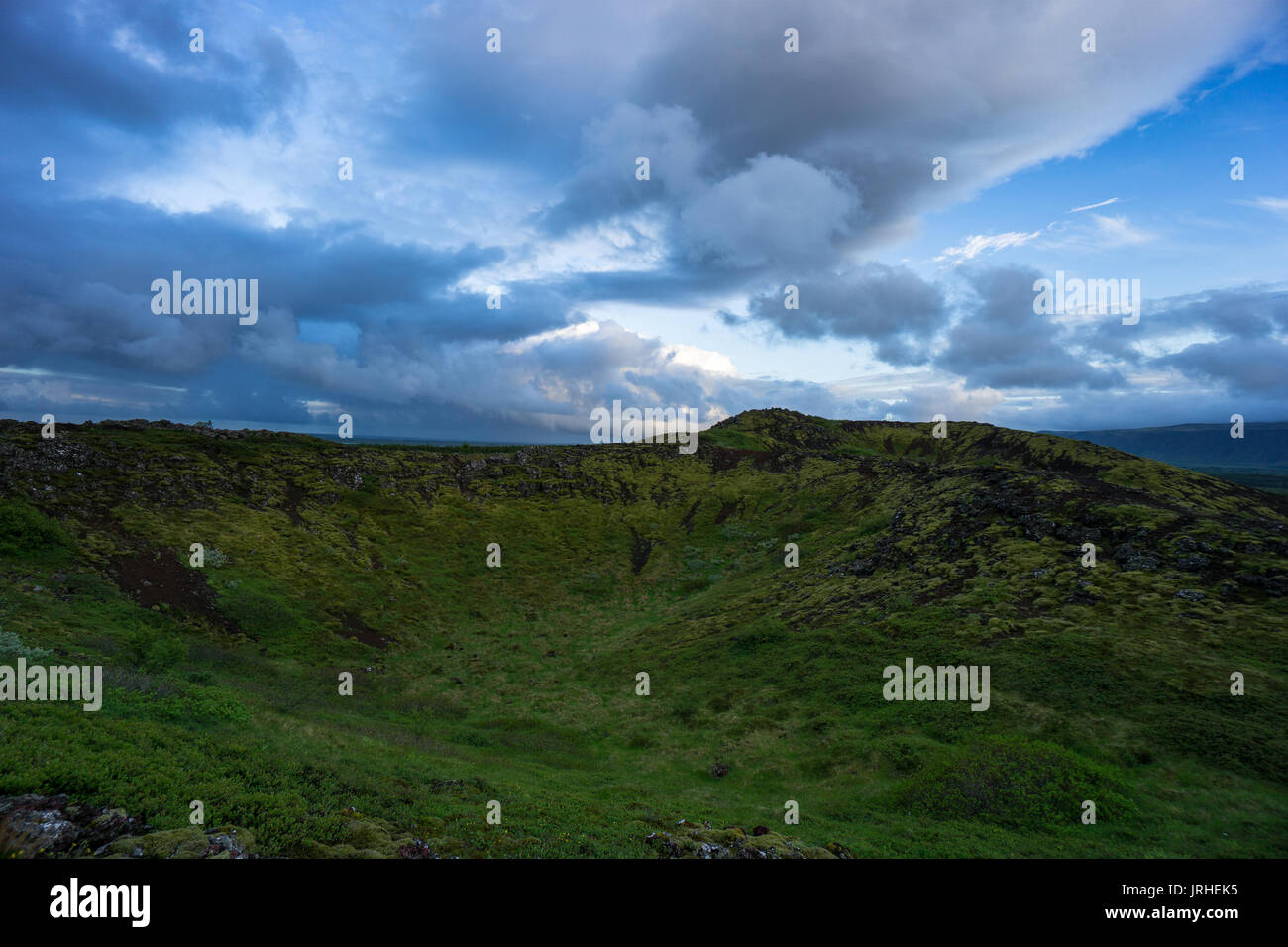 Islanda - le nuvole colorate su verdi montagne vulcaniche all'alba Foto Stock