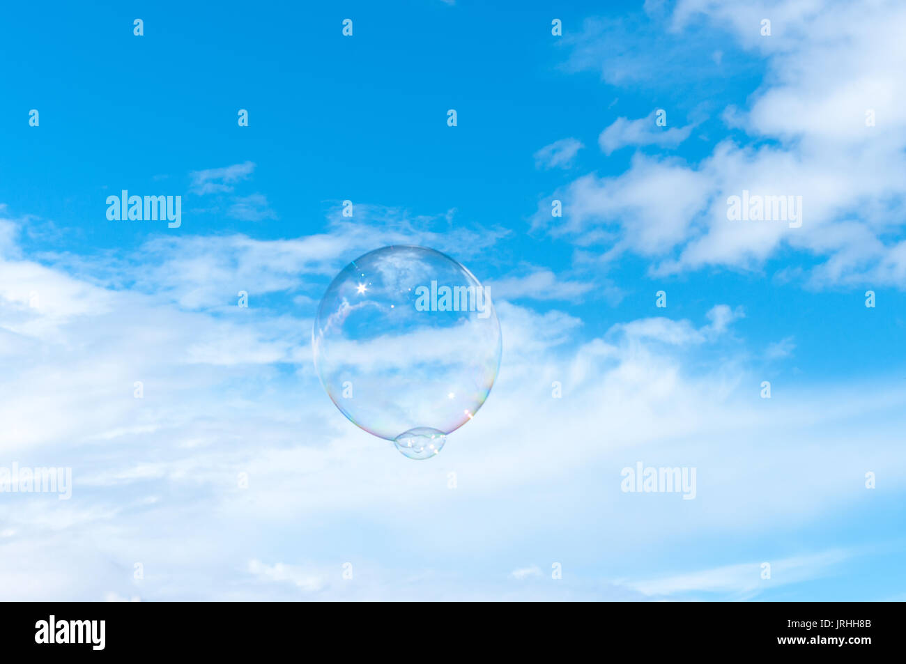 Grande bolla galleggiavano in un chiaro Cielo di estate blu con soffici nuvole bianche. Foto Stock