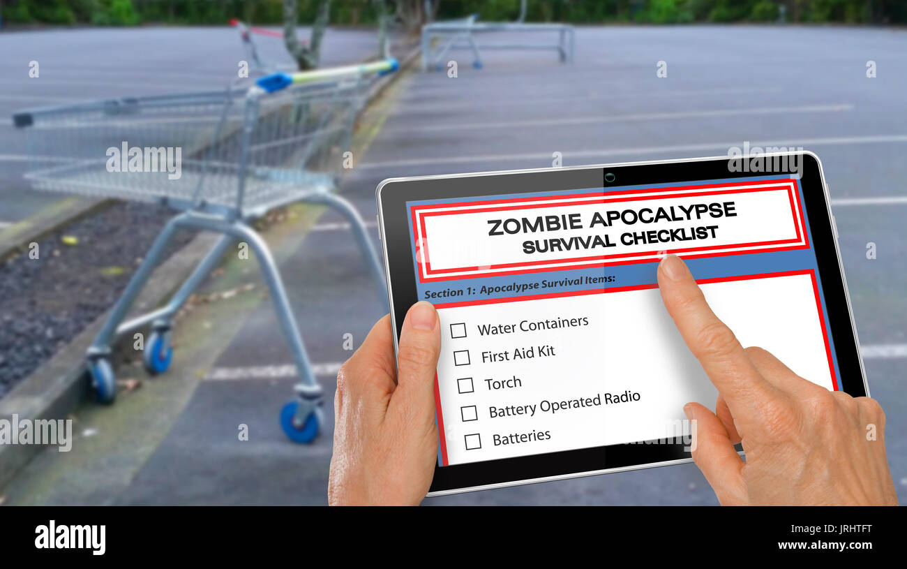 Mano completando Zombie Apocalypse checklist di sopravvivenza sul computer tablet Foto Stock