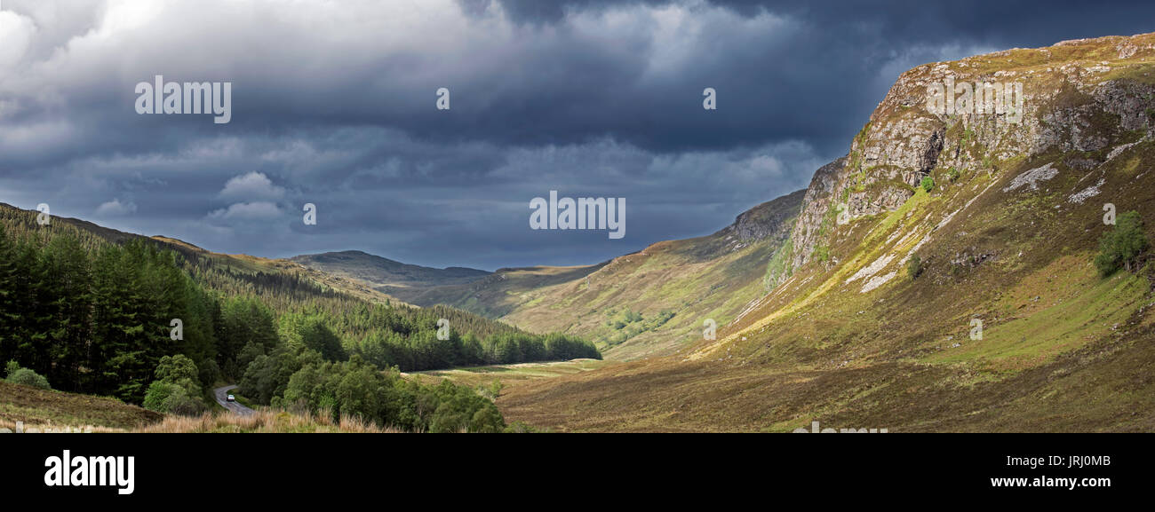 Paesaggio di montagna che mostra oscura pioggia nuvole in rotolamento sulla collina assolata e valley in Wester Ross, Highlands scozzesi, Scotland, Regno Unito Foto Stock