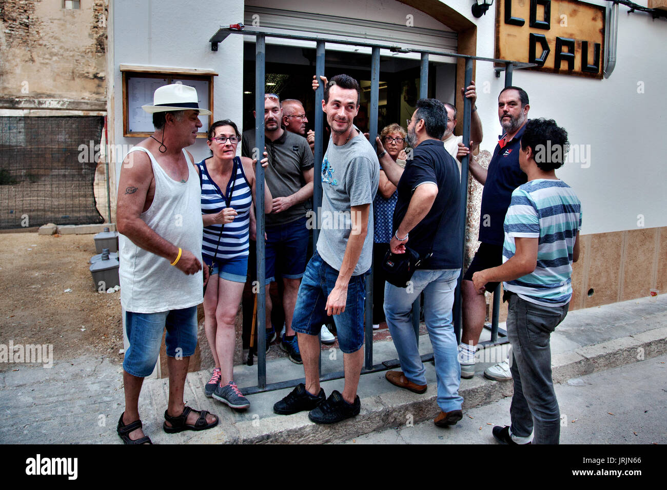 La gente del posto di stand all'interno o facilmente raggiungibili della gabbia di ferro durante la stagione estiva bull in esecuzione evento in Cherta, Tarragona, Spagna. Foto Stock