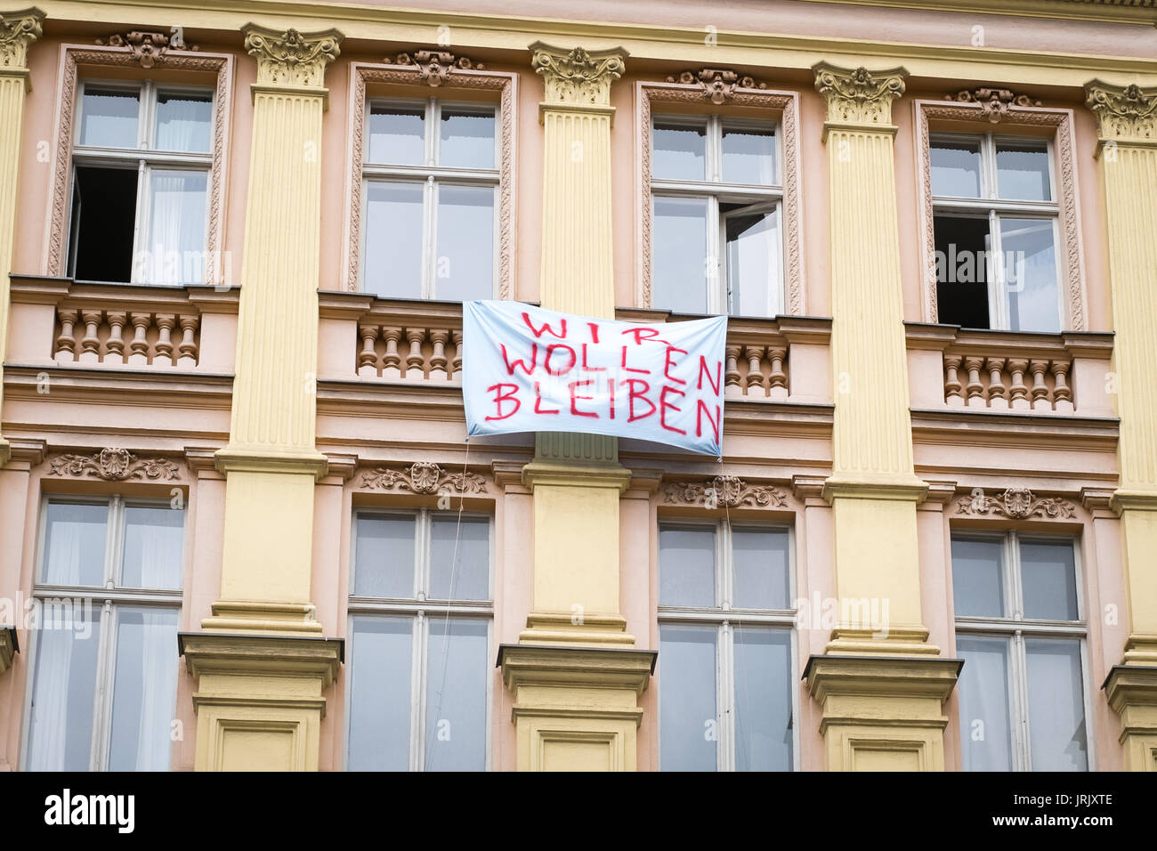 Berlino, Germania - circa agosto 2017: protesta slogan sulla facciata di edificio di Berlino dicendo "Noi vogliamo rimanere' (tedesco: Wir wollen bleiben) Foto Stock
