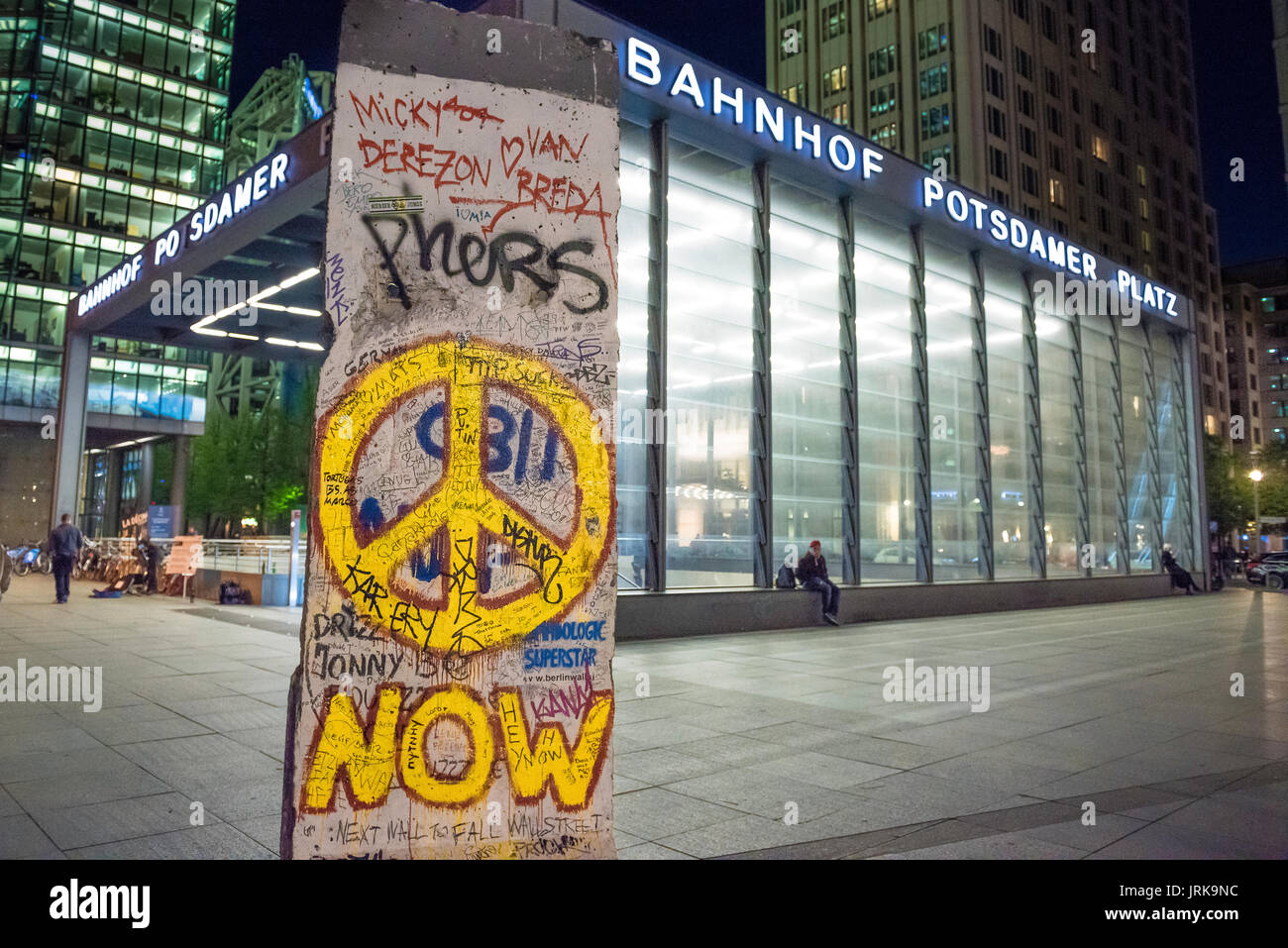 Graffiti del muro di Berlino, vista di una sezione del muro dell'epoca della Guerra fredda che un tempo divise la città in mostra fuori dalla stazione di Potsdamer Platz, Berlino Germania Foto Stock