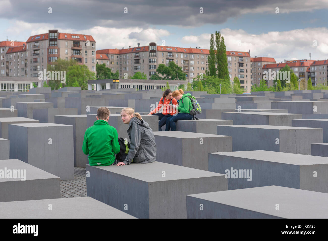 Memoriale dell'Olocausto di Berlino, vista di un gruppo di giovani studenti che si comunicano tra loro durante una visita al Memoriale dell'Olocausto di Berlino, Germania Foto Stock