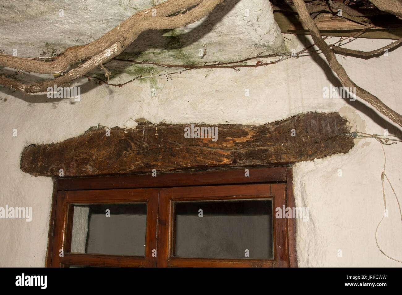 Vacanza home 'Castel' è a qualche centinaio di anni di vecchia casa di pietra in villaggio di montagna Myrthios vicino alla costa sud di Creta con finestra in legno travi Foto Stock