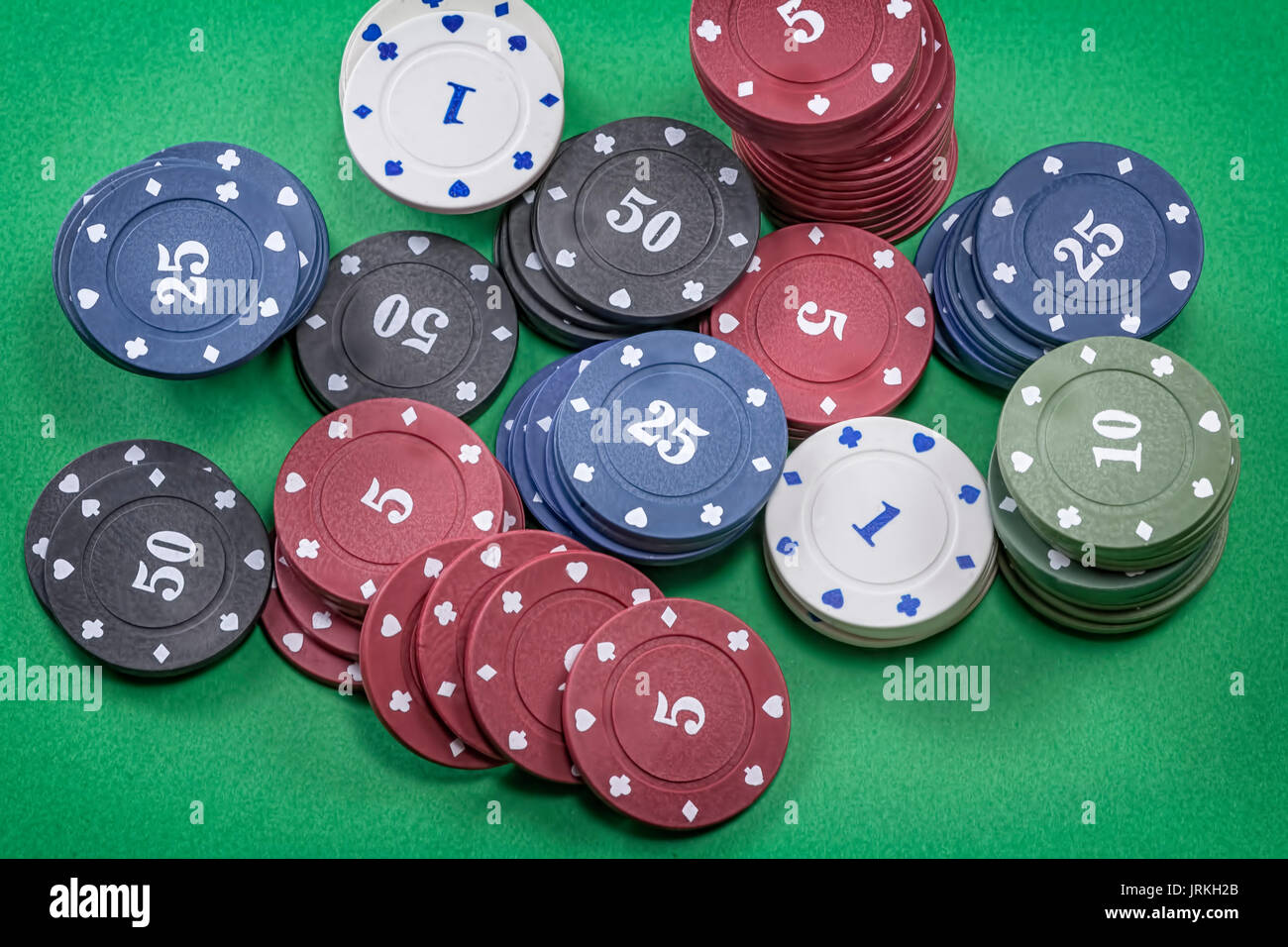 Diversi tipi di poker chips su sfondo verde Foto Stock