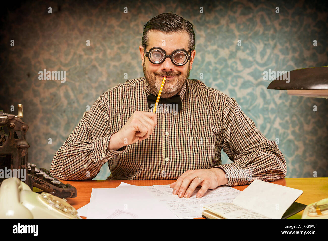 Malinconici office dipendente con una matita nella sua bocca cercando fino negli anni sessanta Foto Stock