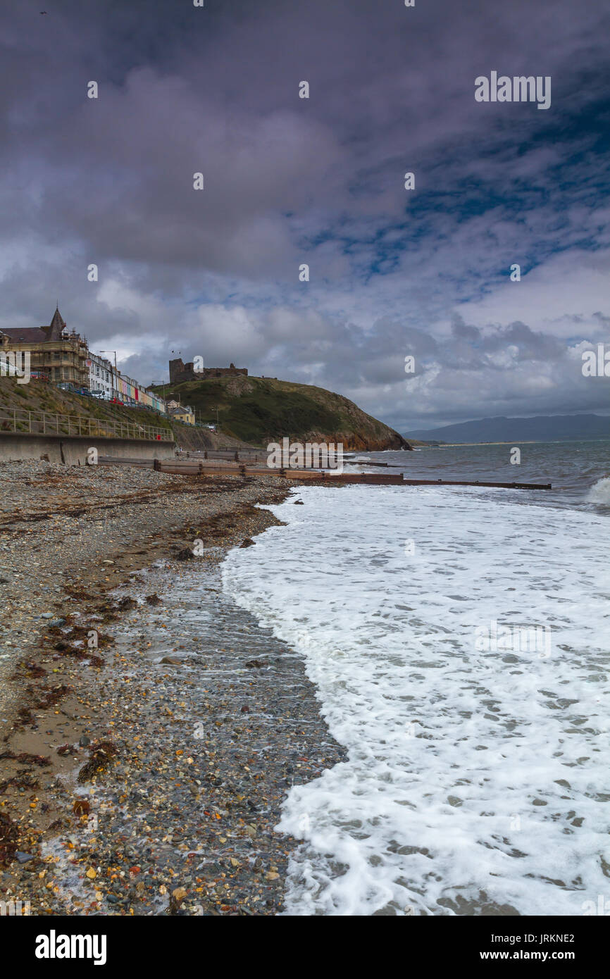 La spiaggia al castello a Criccieth, il Galles del Nord, durante una marea alta su un luminoso giorno di estate Foto Stock