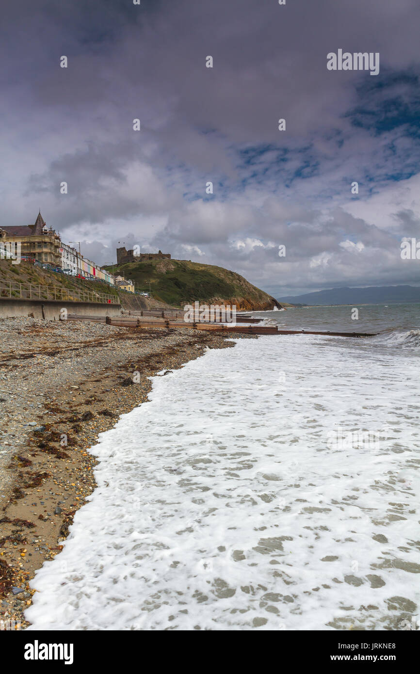 La spiaggia al castello a Criccieth, il Galles del Nord, durante una marea alta su un luminoso giorno di estate Foto Stock