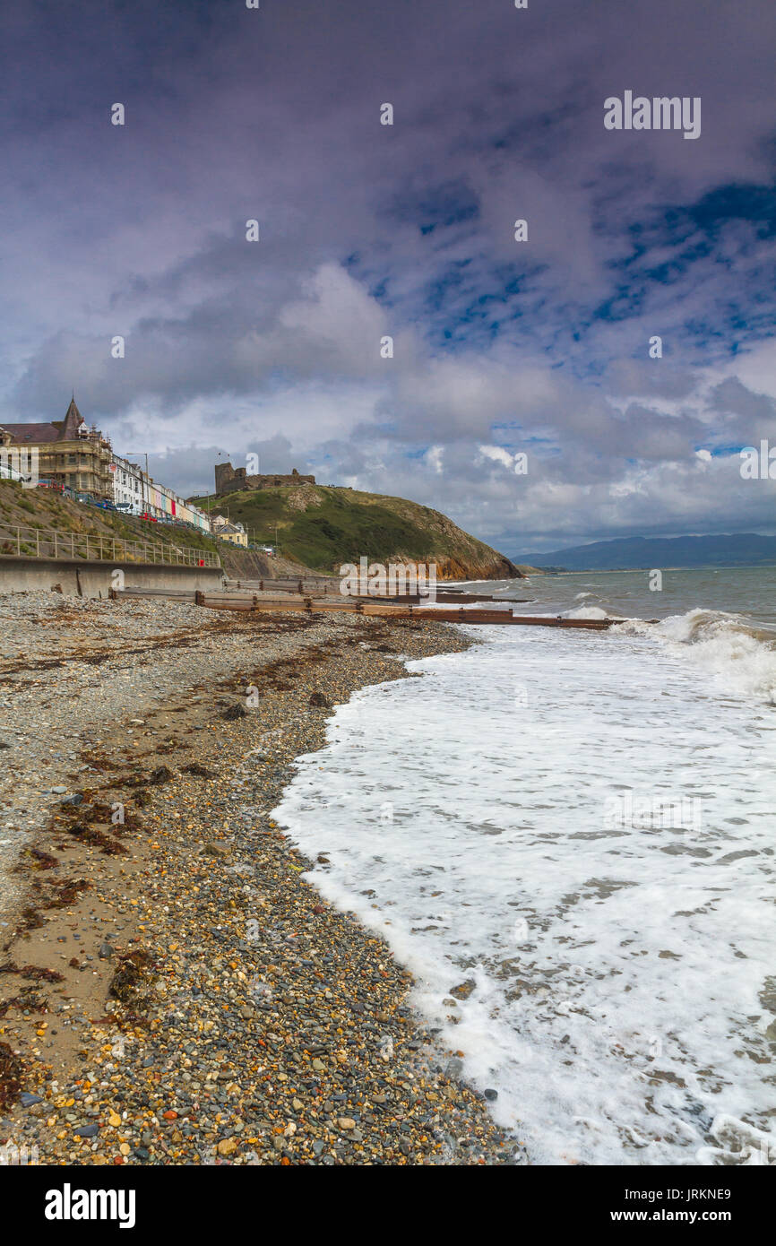 La spiaggia al castello a Criccieth, il Galles del Nord, durante una marea alta su un luminoso giorno di estate Foto Stock