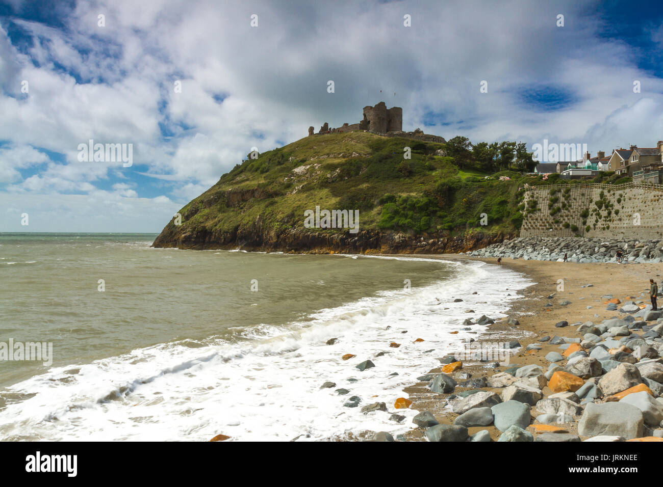 La spiaggia al castello a Criccieth, il Galles del Nord, durante una marea alta su un luminoso giorno di estate Foto Stock