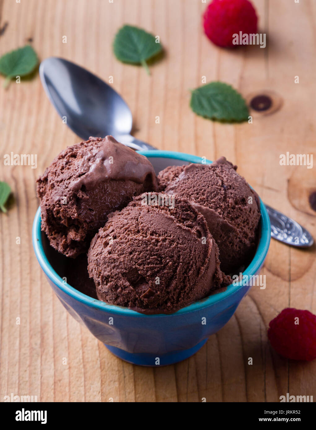 Gelato al cioccolato in tazza blu con lamponi Foto Stock
