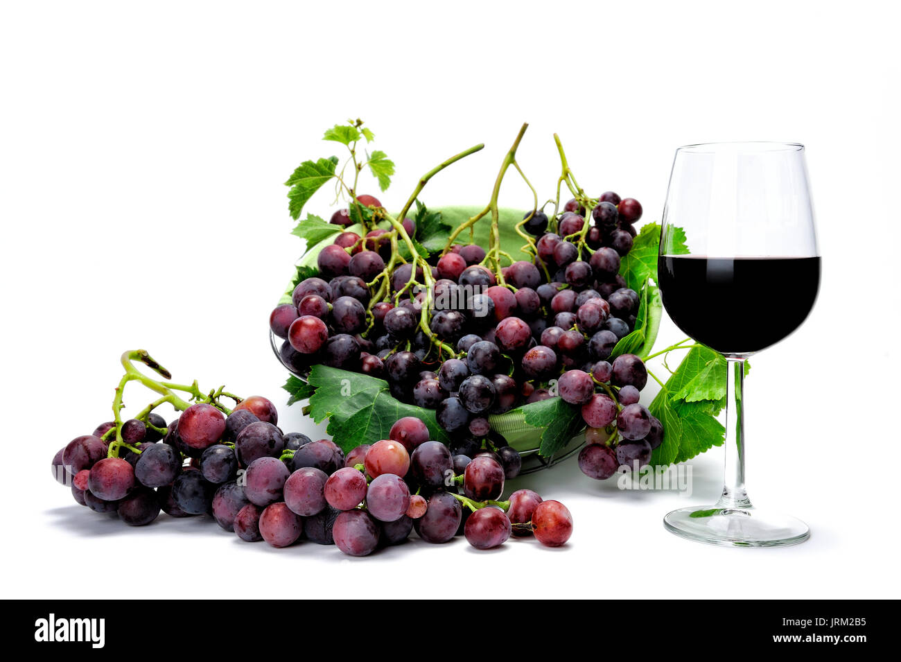 Vino e vetro rosso fresco grappoli di uva fotografato su uno sfondo bianco. Foto Stock