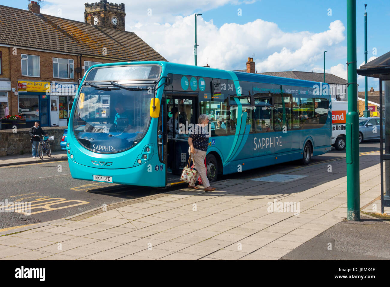 Una signora scende da un Arriva Sapphire bus fornendo un intervallo di 15 minuti servizio su rotte selezionate countrywide qui in Marske dal mare Yorkshire Foto Stock