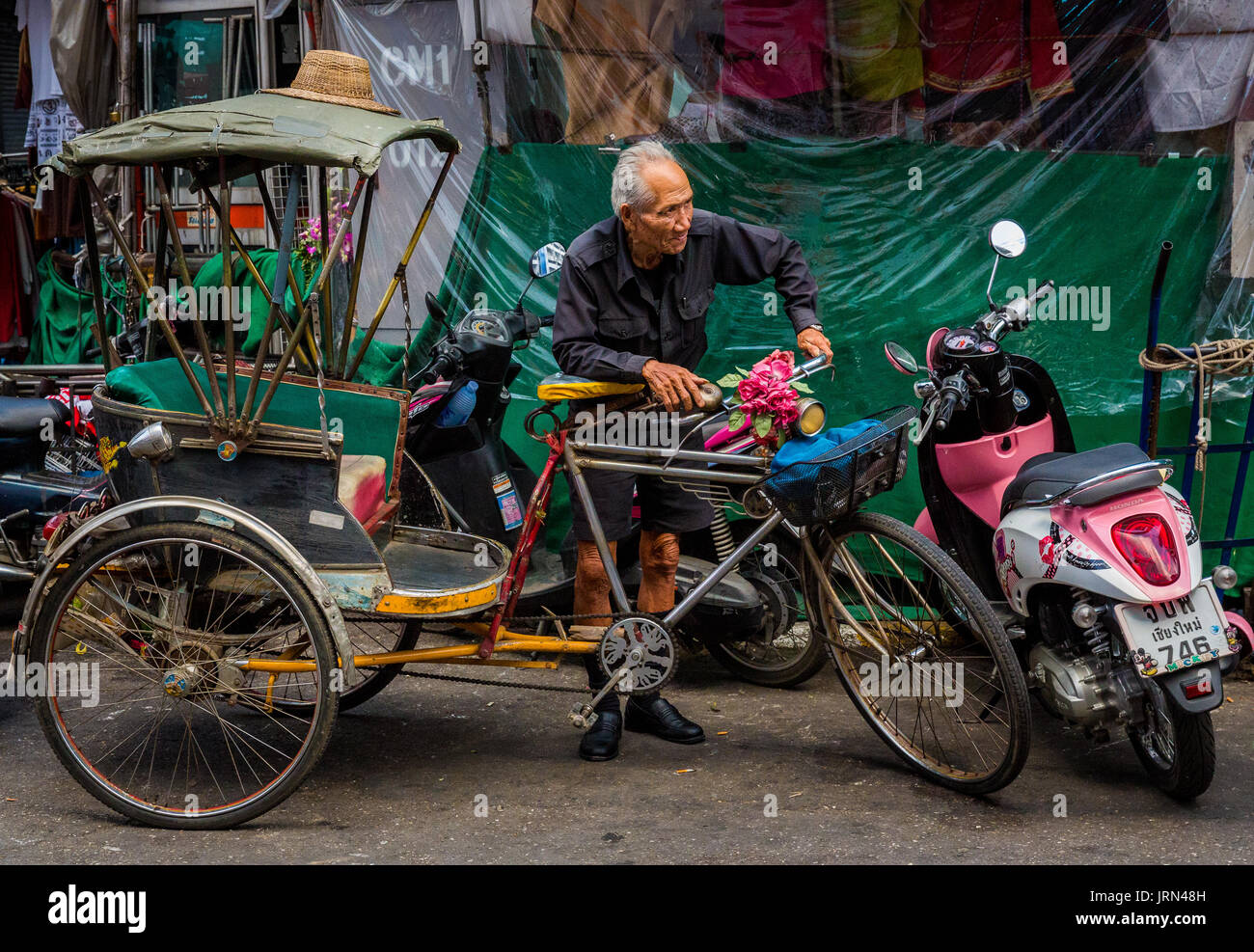 Cycle rickshaw driver con moto nella città vecchia di Chiang Mai, Thailandia. Foto Stock