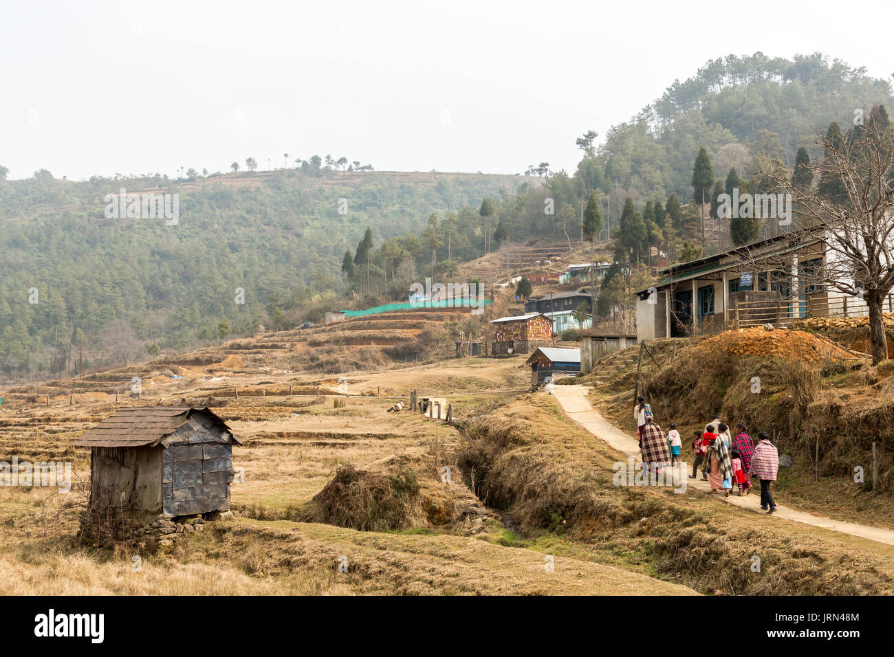 Persone coperte da indossare a piedi case, Meghalaya, India Foto Stock