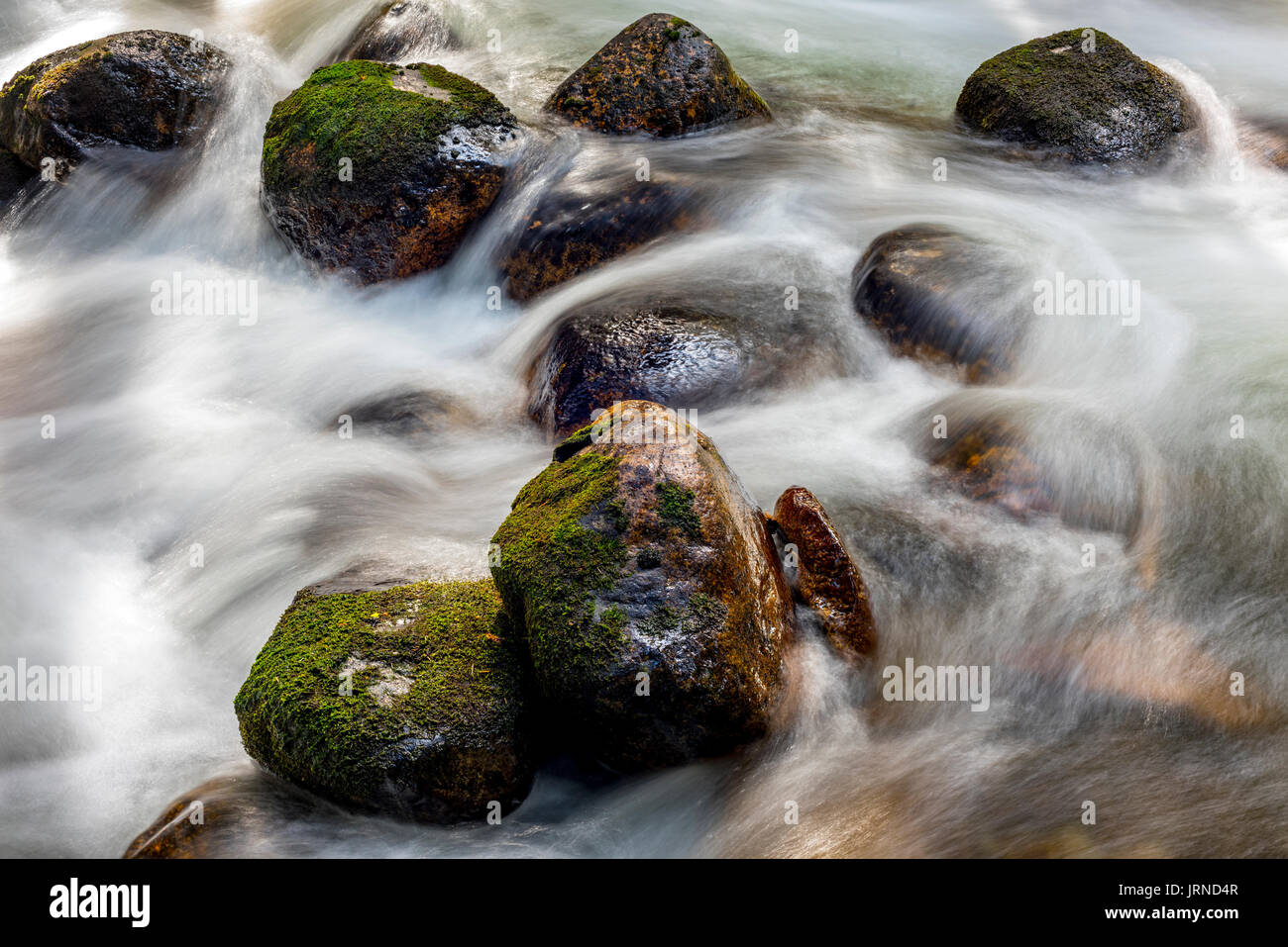 Texture con il flusso delle acque che ne inseguirà intorno rocce Foto Stock