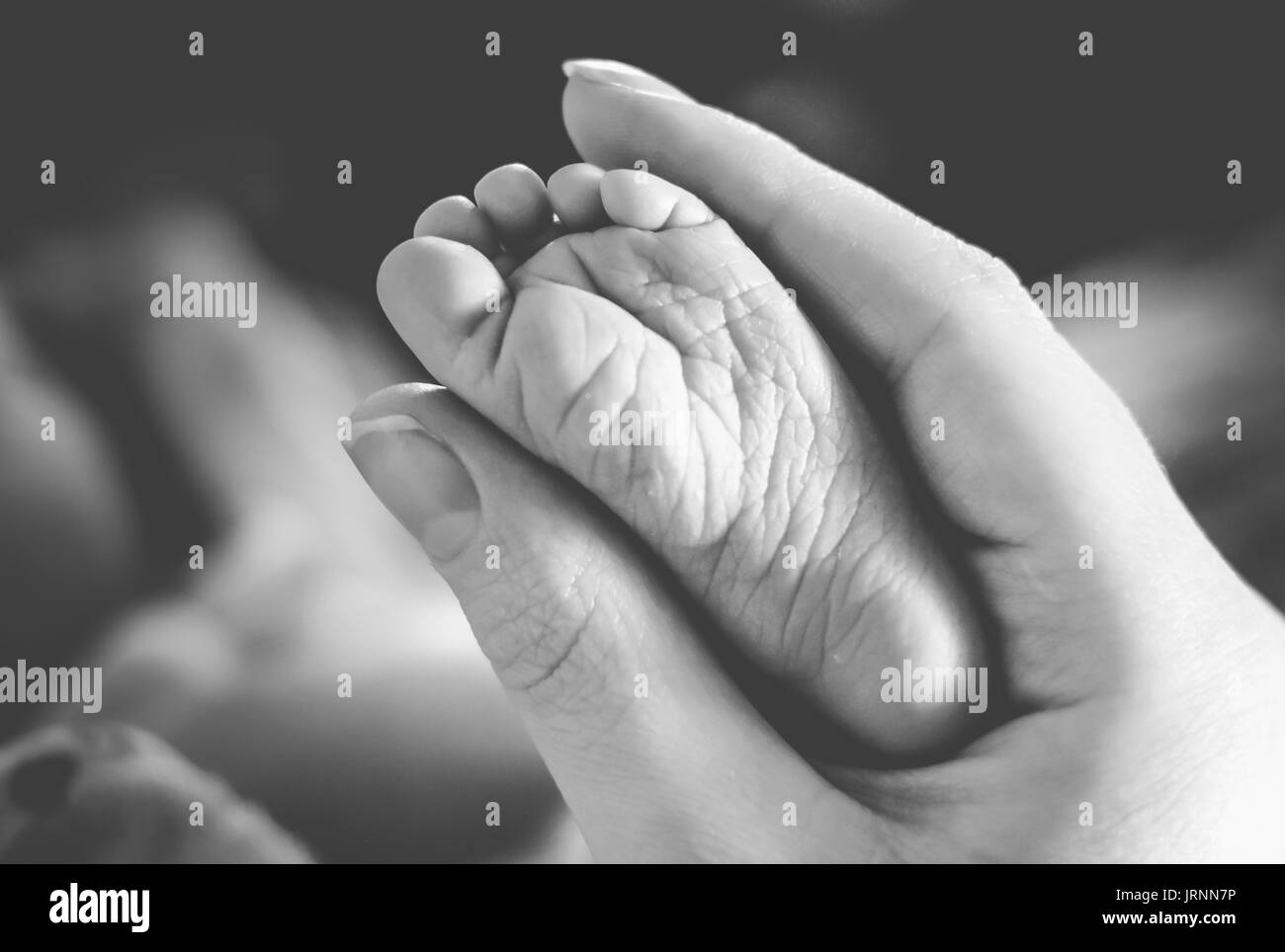 Donna adulta holding del bambino in piedi Foto Stock