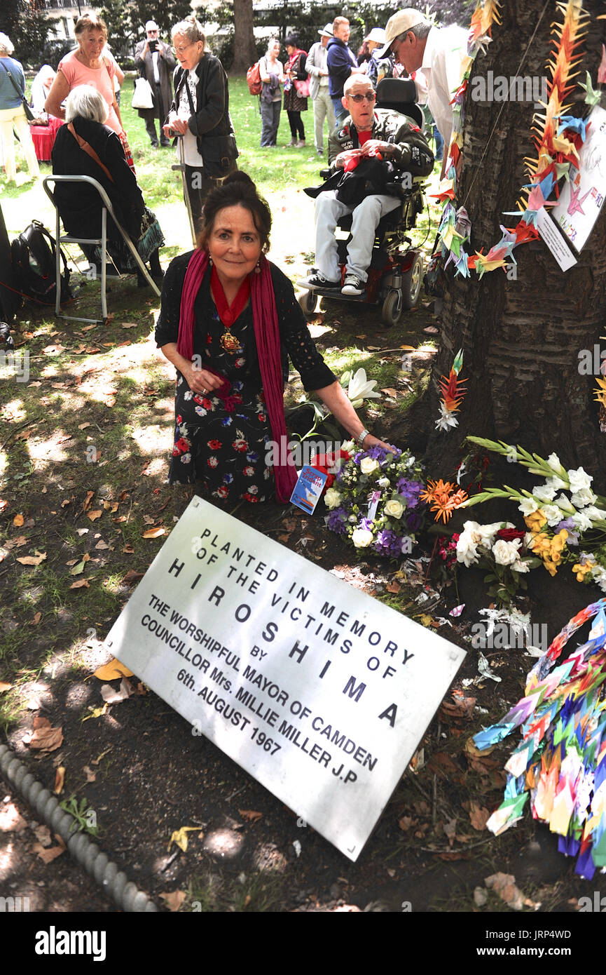 Londra, Regno Unito. 06 Ago, 2017. Cllr Jenny Headlam-Wells (Camden Vice Sindaco) recante fiori sotto il memorial ciliegio in Tavistock Square durante la campagna per il disarmo nucleare la commemorazione annuale del bombardamento atomico di Hiroshima, Giappone in Tavistock Square, Londra, Regno Unito. L'attacco ha avuto luogo alle 8.15, 6 agosto 1945, quando il Enola Gay Boeing B-29 bombardiere Superfortress abbandonato la "Little Boy' bomba atomica, il primo utilizzo dell'arma nella storia. La bomba è stimato per avere ucciso tra 100.000 e 180.000 persone, e ha devastato la città. Credito: Michael presto Foto Stock