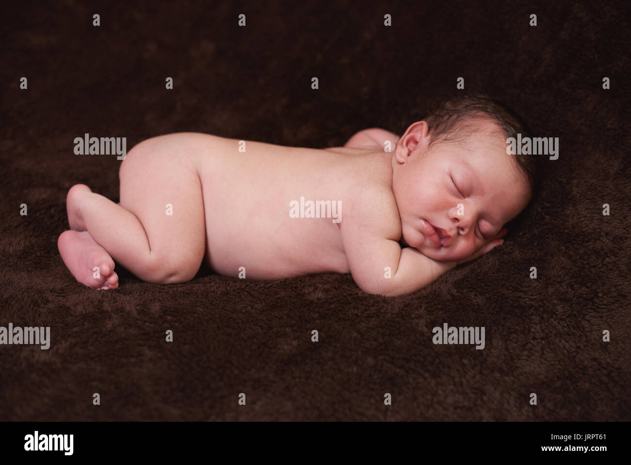 Carino neonato dormire sulla coperta di marrone a piena lunghezza Foto Stock
