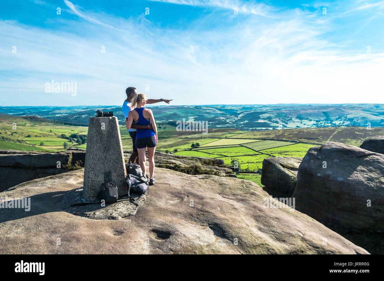 Un giovane godendo il Peak District campagna da un roccioso vantage Foto Stock Un giovane godendo il Peak District campagna da un roccioso vantage Foto Stock