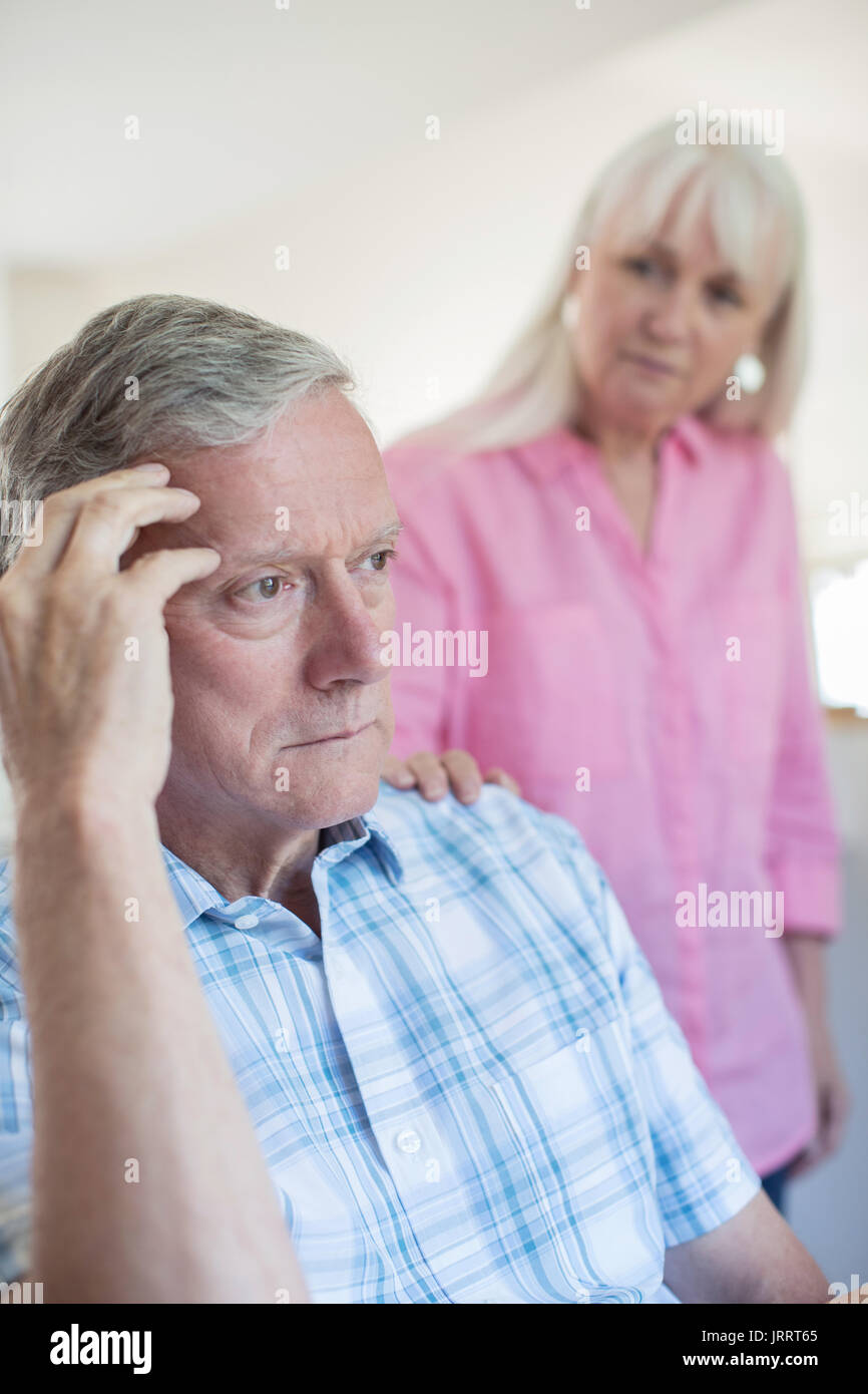 Donna matura consolante l uomo con la depressione a casa Foto Stock