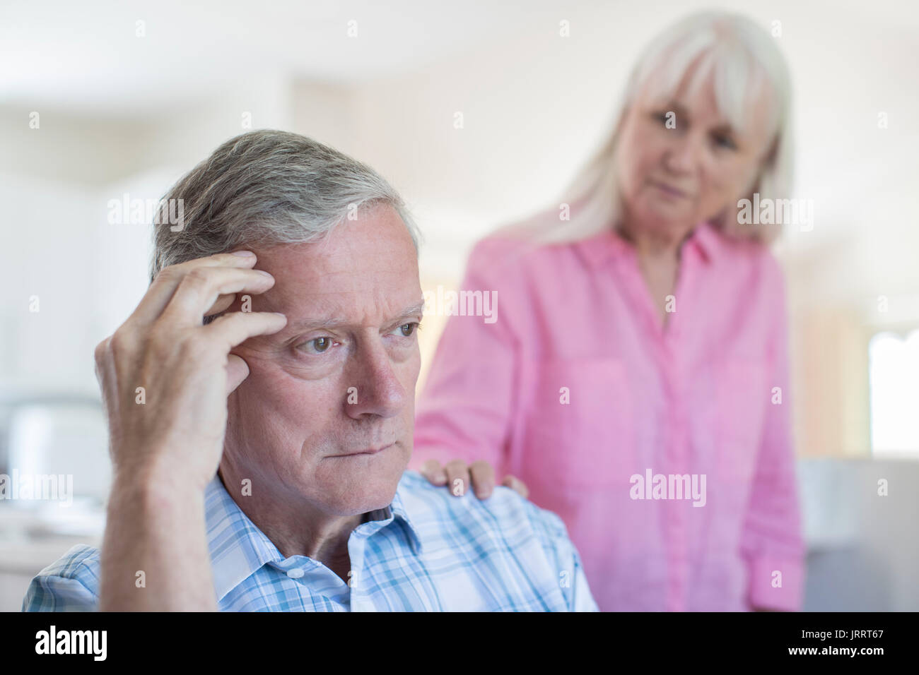 Donna matura consolante l uomo con la depressione a casa Foto Stock