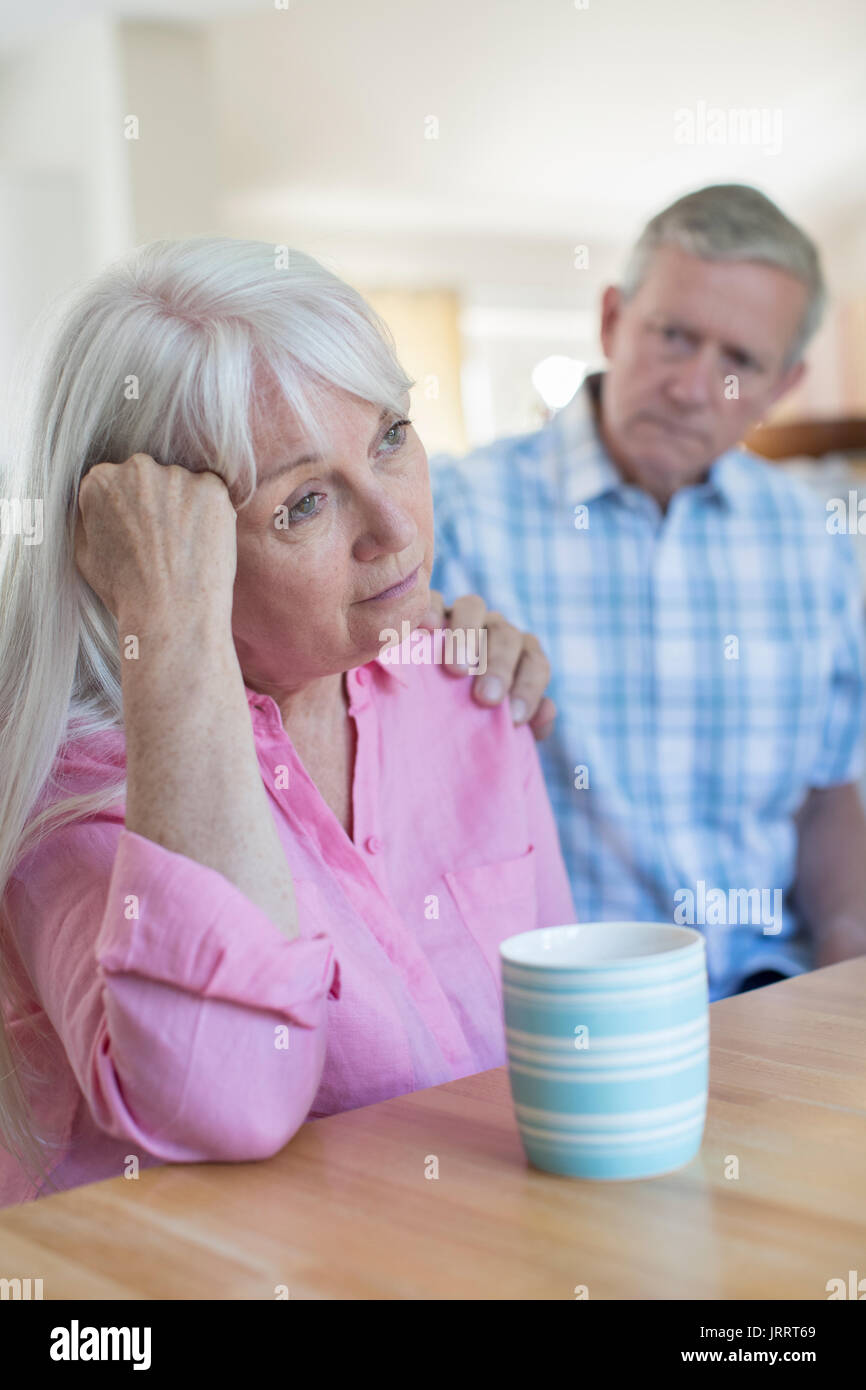 Uomo maturo consolante donna con depressione a casa Foto Stock