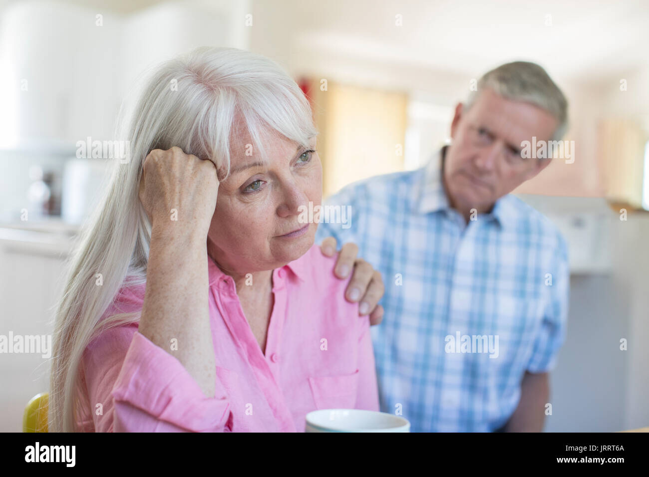 Uomo maturo consolante donna con depressione a casa Foto Stock