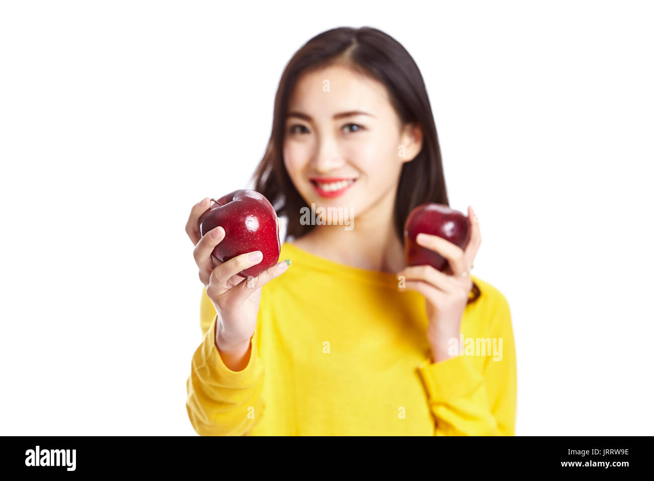 Giovane e bella donna asiatica che mostra due mele rosse, isolato su sfondo bianco, mangiare sano concetto. Foto Stock