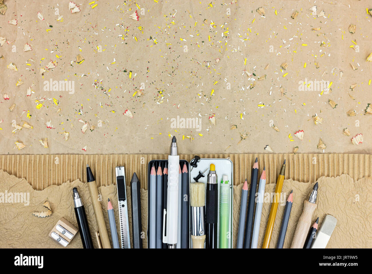 Arte del disegno. diversi strumenti di disegno su carta marrone sfondo con matite trucioli. Foto Stock