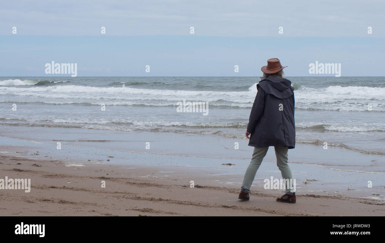 Guardando le onde venire in, Druridge bay, Northumberland Foto Stock