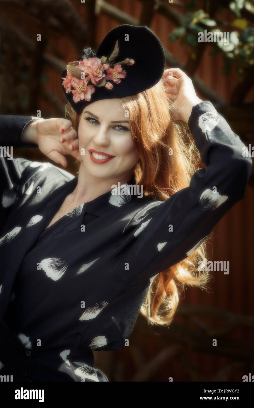 Sorridente giovane donna indossa floral Vintage dress e hat Foto Stock