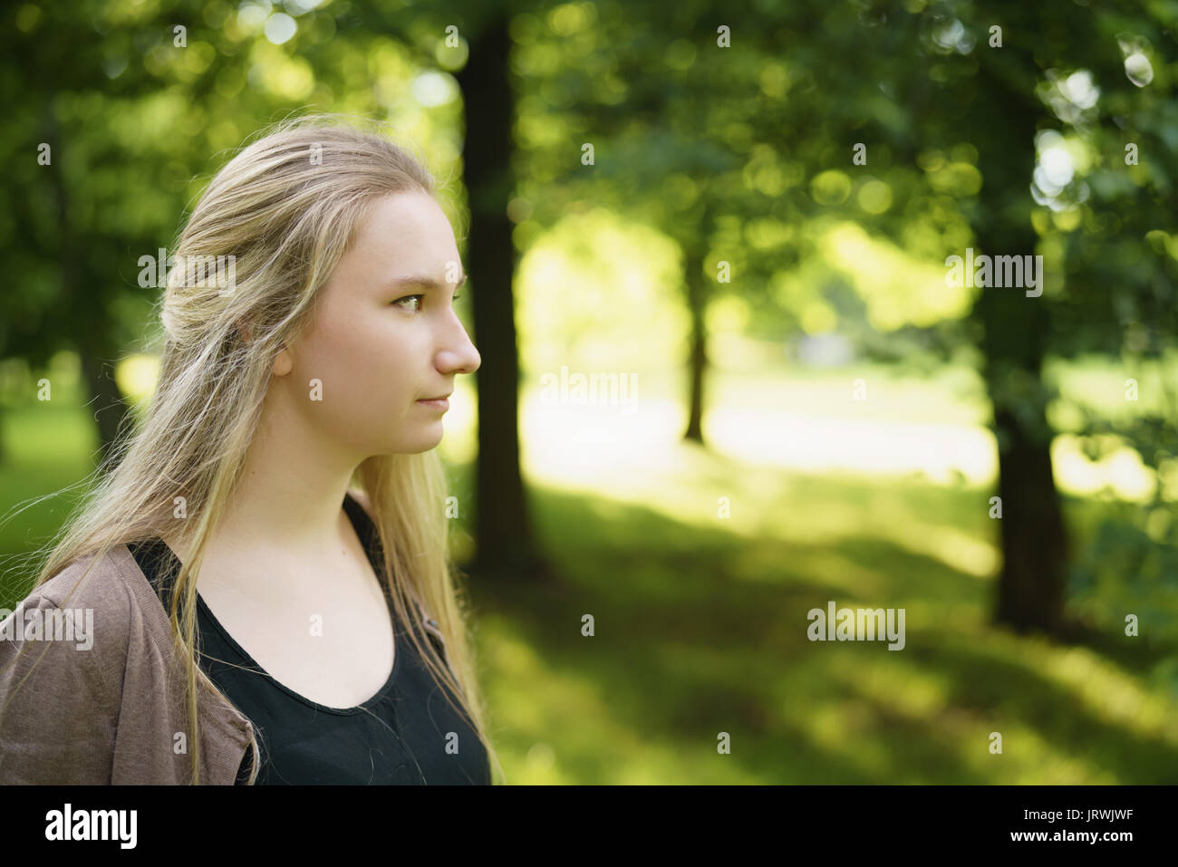 Teen ragazza ritratto nel parco verde nella soleggiata giornata estiva Foto Stock