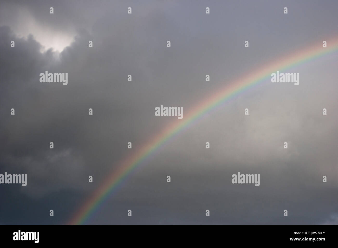 Rainbow arco contro un cielo scuro e nuvole di tempesta Foto Stock